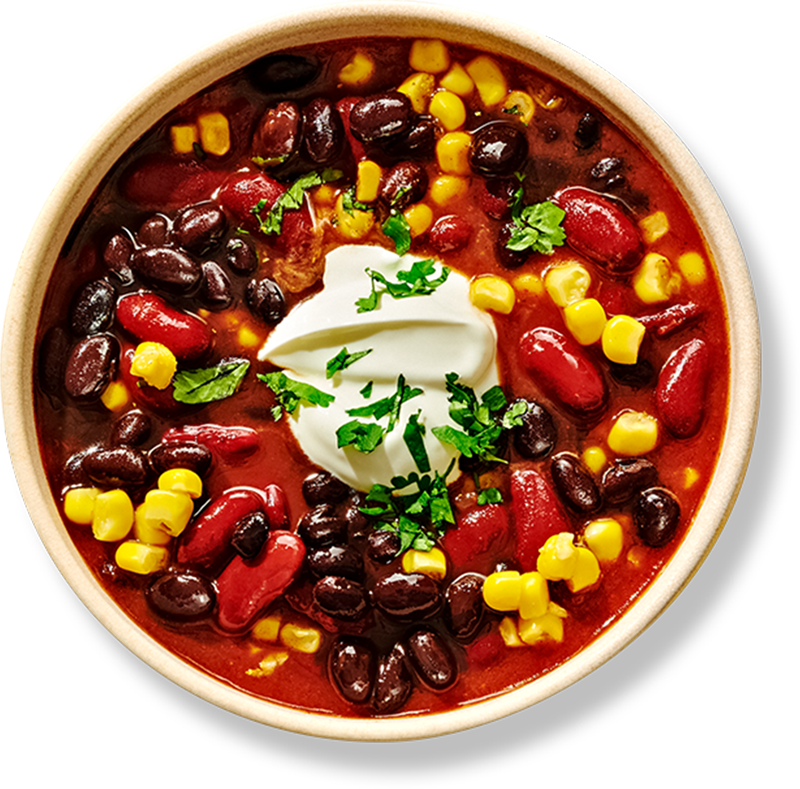 Bowl of chili with black beans, kidney beans, and corn topped with sour cream